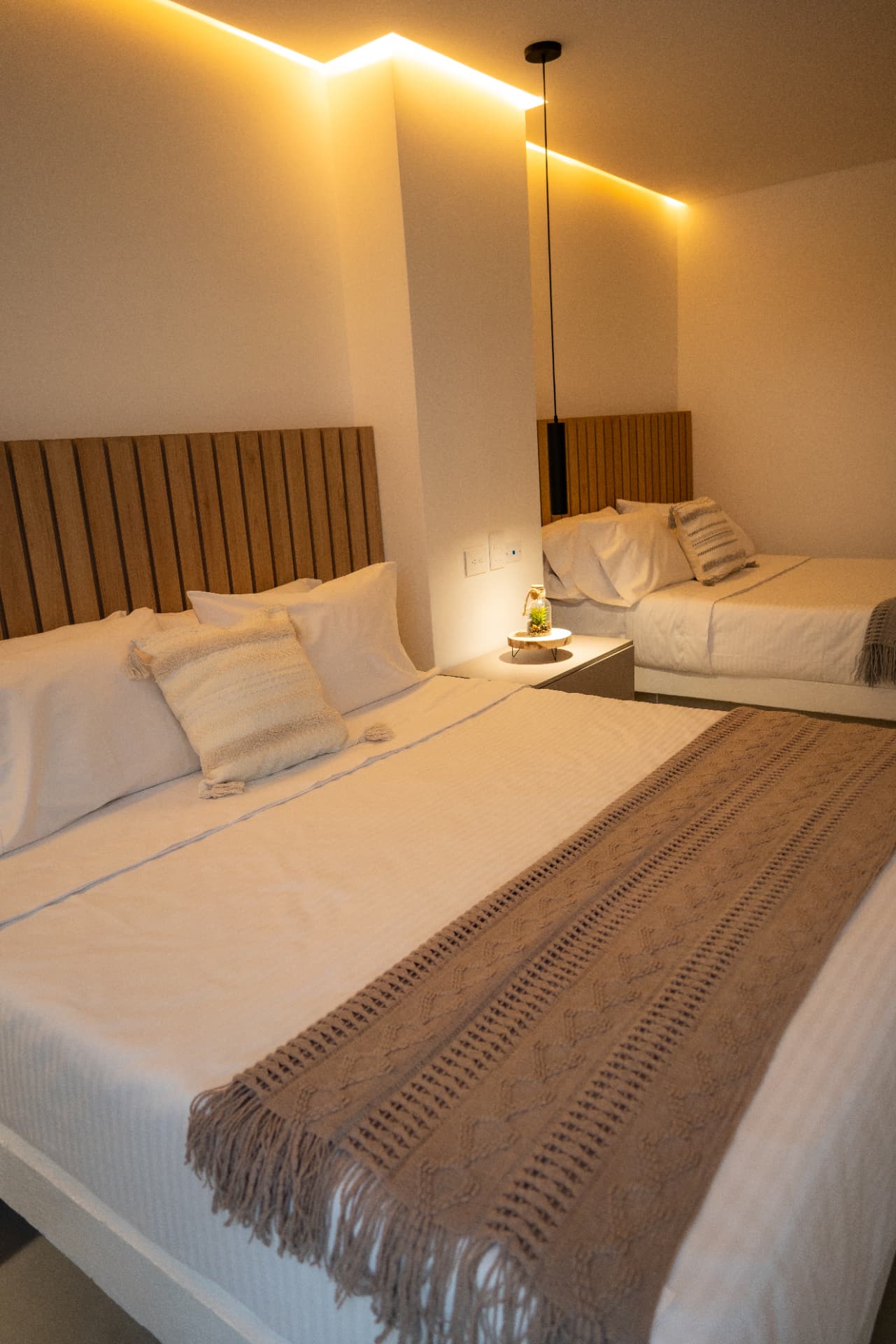 Habitación Familiar — camas con iluminación cálida